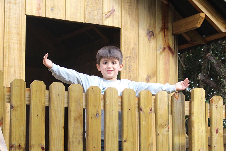 Aluno brincando em casa na árvore de escola cristã bilíngue